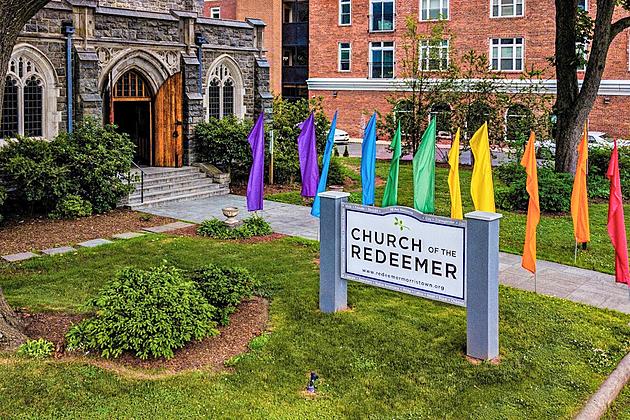 Church of the Redeemer signage with rainbow flags front on display.